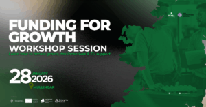 Group of professionals attending a business workshop, with a speaker presenting funding strategies for manufacturing companies